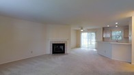 Located at 5885 Tuttle's Grove Blvd in Dublin, Ohio, this two-floor home offers a welcoming and functional layout designed for comfortable living. The main living area is generously proportioned, featuring plush wall-to-wall carpeting and a classic tile-surround fireplace that serves as a natural focal point of the room. A ceiling fan overhead adds practicality and comfort to the space. Large sliding glass doors flood the living area with abundant natural light while providing a seamless connection to the outdoors and views of the surrounding greenery. Adjacent to the living space, a pass-through counter connects to the kitchen area, promoting an open, communicative flow between rooms that is ideal for both everyday living and entertaining. The neutral, light-toned walls and flooring throughout create a clean, versatile backdrop that adapts easily to a variety of interior styles. Spanning two floors, the home provides ample room for separation between living and private spaces. Situated in the desirable Dublin, Ohio community, this property benefits from its established neighborhood setting while offering a well-appointed interior that balances warmth and practicality.