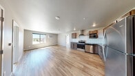This 2-bedroom, 2-bathroom unit at 5652 36th Ave S in Fargo, North Dakota offers a well-designed single-floor layout that makes efficient use of its space. Light wood-tone flooring flows consistently throughout every room, creating a cohesive and clean aesthetic.

The kitchen is a standout feature, outfitted with warm-toned wood cabinetry, granite-look countertops, and a classic white subway tile backsplash. Stainless steel appliances — including a range with a wall-mounted range hood, dishwasher, microwave, and refrigerator — complete the functional and stylish cooking space. Recessed lighting overhead keeps the area bright and open.

The kitchen connects seamlessly to the living room, forming an open-concept common area well-suited for everyday living. Both bedrooms are comfortably sized, with the primary bedroom featuring a ceiling fan and a sliding window that brings in natural light and open outdoor views. The second bedroom also benefits from natural light through its windows. Baseboard heating units are present throughout the unit.

The two bathrooms are finished with wood cabinetry and granite-look countertops that echo the kitchen's design language, maintaining visual consistency across the unit. Light wood flooring continues into the bathrooms, reinforcing the home's unified interior palette. A dedicated closet provides additional storage.