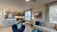 This 2-bedroom, 2-bathroom single-story residence offers a thoughtfully designed open-concept floor plan that maximizes both space and functionality. The living area serves as the heart of the home, featuring light wood-style flooring, a ceiling fan, and multiple windows that allow generous natural light to fill the room. The seamless flow connects the living space to a dedicated dining area and a well-equipped kitchen.

The kitchen is a standout feature, showcasing dark wood cabinetry extending to the ceiling, a classic subway tile backsplash, stainless steel appliances including a French door refrigerator, electric range, and built-in microwave. A large island with a white quartz countertop and undermount sink provides additional workspace and casual seating.

Both bedrooms are comfortably sized and feature ceiling fans, large windows with outdoor views, and light wood-style flooring. Each room benefits from its own dedicated bathroom. The bathrooms feature dark wood vanities with white countertops, framed mirrors, and glass-enclosed showers. One bathroom includes an elongated vanity with ample storage. Light, neutral tones throughout the residence create a cohesive and inviting atmosphere.