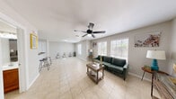 This 1-bedroom, 1-bathroom unit delivers a functional and well-appointed layout across a single floor. The living room is bright and welcoming, featuring large windows with blinds that allow natural light to fill the space, light tile flooring, and a ceiling fan overhead. The open feel is complemented by neutral-toned walls throughout. The kitchen is a standout feature, showcasing warm wood cabinetry, dark granite countertops, and stainless steel appliances including a range and dishwasher — combining both style and practicality. An entry area with tile flooring and a window provides a natural transition into the main living spaces. The bedroom offers a cozy retreat with rich hardwood-style flooring, a ceiling fan, a window with natural light, and ample room for furnishings. The bathroom is cleanly finished with warm wood cabinetry, a light stone-top vanity, overhead storage, and a full shower-tub combination. Consistent neutral tones and tile flooring in the common areas tie the unit together, creating a cohesive and inviting atmosphere throughout.