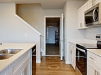 This two-story property in Ankeny, Iowa, offers a blend of modern amenities and practical features. The home boasts a spacious garage with a high ceiling, ample floor space, and an automatic door opener, providing secure parking and potential storage options. The bathroom is well-appointed, featuring a combination bathtub and shower with built-in shelving, complemented by a modern toilet and towel rack.

The laundry area is equipped with a side-by-side washer and dryer set, topped with a convenient wire shelf for storage. A generously sized walk-in closet with wall-to-wall wire shelving offers abundant storage space. The living area showcases an inviting ambiance with a modern electric fireplace, ceiling fan, and large windows that allow natural light to flood the room.

The kitchen is a highlight, featuring sleek white cabinetry, stainless steel appliances, and a central island, all set against warm hardwood flooring. Bedrooms are carpeted for comfort, with ample closet space and windows for natural light. The property's layout, as seen in the 3D model, reveals an efficient use of space with well-connected rooms. Throughout the home, neutral tones dominate, creating a bright and airy atmosphere that allows for personalized decor. This property combines functionality with modern design, offering a comfortable living space in a desirable location.