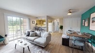 Located at 550 S DuPont Parkway in New Castle, Delaware, this single-floor residence offers a well-designed layout with a lively, eclectic aesthetic throughout. The open-concept living and dining area forms the heart of the home, featuring light wood-style flooring, a ceiling fan, and a bold teal accent wall in the dining space that anchors a stylish wood dining table. Large windows allow natural light to fill the room, creating a warm and welcoming atmosphere that flows seamlessly into the kitchen. The kitchen is equipped with wood-toned cabinetry, white appliances including a refrigerator, range, microwave, and dishwasher, along with a breakfast bar that connects to the living area. The residence includes multiple bedrooms, each with its own distinct character. One bedroom features a striking orange accent wall paired with carpeted flooring, while another is finished in soft aqua tones and offers flexible space with room for a loft bed and workspace. A third bedroom is neutral and serene. Two bathrooms serve the home — a full bath with a tub/shower combo and white cabinetry, and a compact half bath with a clean, minimalist vanity. Light wood-style flooring runs throughout the main living areas, contributing to a cohesive and contemporary feel across the entire space.
