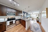 Located at 131 Ponce de Leon Ave NE in Atlanta's vibrant Old Fourth Ward neighborhood, this 1-bedroom, 1-bathroom unit offers a thoughtfully designed open-concept layout. The combined living and dining area flows seamlessly from the kitchen, creating an expansive, connected feel enhanced by track lighting, a ceiling fan, and large windows that invite abundant natural light.

The kitchen is a standout feature, showcasing rich dark-wood cabinetry that extends to the ceiling, a full suite of stainless steel appliances, a subway tile backsplash, and granite countertops. A peninsula with pendant lighting provides a casual dining space with seating for two, doubling as a convenient breakfast bar.

The bedroom is a serene retreat, distinguished by a bold navy accent wall, hardwood-style flooring, a ceiling fan, and a generously sized window with views to the exterior. Three closets throughout the unit offer ample storage.

The bathroom features a double-sink vanity with granite countertops, dark cabinetry, a large mirror, and a tiled tub/shower combination. Additional practicalities include a dedicated laundry area and a utility room. Consistent hardwood-style flooring runs throughout the main living spaces, tying the unit's modern, cohesive aesthetic together.