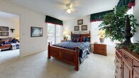 Located at 2562 Tenth St in Sarasota, Florida, this single-floor residence offers a thoughtfully arranged open-concept layout that connects the living, dining, and kitchen areas seamlessly. The living room is generously sized with plush carpeting, a sliding glass door that invites natural light, and direct access to an outdoor area. A large mirror accent wall in the dining area enhances the sense of openness, complementing the circular glass-top dining table and wicker seating beneath. The kitchen is efficiently designed with white cabinetry, light countertops, wood-look flooring, and a breakfast bar with bar stool seating — ideal for casual dining. The primary bedroom is spacious and bright, benefiting from multiple windows and a ceiling fan, with sliding glass door access to the outdoors. The second bedroom is cozy and well-lit, featuring a window with blinds and ample space for furnishings. Both bathrooms are finished with wood-look flooring, tub-shower combinations, vanity cabinetry, and clean neutral tones. Throughout the residence, a consistent palette of light walls and warm flooring materials creates a comfortable, welcoming ambiance well-suited to Florida living.