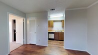 Located at 701 N Indiana Ave in Lubbock, Texas, this single-story space offers a straightforward and functional layout designed for comfortable everyday living. The interior features warm hardwood-style flooring that extends through the main living areas, adding a sense of continuity and warmth throughout the space.

The kitchen is accessible directly from the main living area and is equipped with wood-toned cabinetry providing ample storage, a built-in dishwasher, a sink with a practical layout, and tiled countertops. Overhead fluorescent lighting ensures the kitchen is well-lit for meal preparation. A ceiling-mounted HVAC vent contributes to efficient climate control throughout the unit.

The living area is defined by clean, neutral-toned walls and crown molding details, lending a polished finish to the interior. A louvered door near the kitchen entry provides access to additional storage or utility space, adding to the overall practicality of the floor plan.

The textured ceilings are consistent throughout, giving the space a classic residential character. The overall ambiance is clean, neutral, and move-in ready, making this Lubbock property a functional and accessible option in its neighborhood.