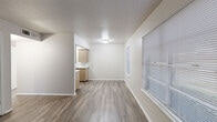 This compact and efficiently designed one-bedroom, one-bathroom unit spans a single floor, making thoughtful use of every square foot. The layout connects a living room, kitchen, bedroom, bathroom, and hallway in a functional flow throughout the space.

The living room greets you at the entry, featuring a large window with horizontal blinds that allows natural light to fill the room. Wood-look laminate flooring runs throughout the entire unit, lending a cohesive and clean aesthetic to every area.

The galley-style kitchen is well-equipped, featuring tan cabinetry with ample upper and lower storage, a double-basin sink, a black electric range, a refrigerator, and a ventilation hood. The light countertops provide a practical workspace for meal preparation.

The bedroom is a comfortable, well-proportioned room with a window overlooking the exterior, bringing in natural light. It includes a closet with double bi-fold doors and a full-length hanging rod, along with an additional built-in storage cabinet for added convenience.

The bathroom offers a tiled tub and shower surround, a toilet, and a single-sink vanity with matching tan cabinetry and a light countertop. A window with blinds and a large mirror above the vanity add brightness to the room. White walls and trim throughout the unit contribute to a clean, neutral palette.