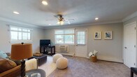 Located at Fairfield New England Village in Hauppauge, New York, this single-floor residence offers a thoughtfully designed layout with a warm, neutral aesthetic throughout. The living room is generously proportioned, featuring soft carpeting, crown molding, recessed lighting, and a ceiling fan. Multiple windows invite natural light and provide outdoor views, while a wall-mounted AC unit ensures year-round comfort. A door provides direct exterior access, adding convenience.

The dining area is defined by elegant crown molding and hardwood-style flooring, creating a refined setting for meals. The kitchen is well-equipped, showcasing rich wood cabinetry, dark granite countertops with a contrasting tile backsplash, a dishwasher, and a window overlooking the outdoors.

The bedroom is a serene retreat, complete with plush carpeting, crown molding, recessed lighting, a ceiling fan, and two spacious double-door closets with built-in shelving. A wall-mounted AC unit adds individualized climate control.

The bathroom features a full tub-shower combination enclosed by sliding glass doors, accented with classic white tile and subtle diamond detail work. Carpeted stairs suggest additional accessible storage or utility space below. Throughout, the space maintains a cohesive, comfortable character.