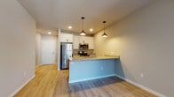 Located at 4604 Hammersley Rd in Madison, Wisconsin, this thoughtfully designed single-floor residence offers a clean, contemporary aesthetic throughout. The open-concept living and kitchen area is anchored by light-toned luxury vinyl plank flooring that flows seamlessly from room to room, creating a bright and cohesive atmosphere.

The kitchen is a standout feature, showcasing white shaker-style cabinetry, granite countertops, and a full suite of stainless steel appliances, including a refrigerator, electric range, and microwave. A peninsula with an integrated sink and pendant lighting above serves as both a functional workspace and an informal dining area, opening naturally into the living space.

The living area is generously proportioned, with neutral-toned walls and recessed lighting contributing to an airy, welcoming ambiance. Sliding glass doors lead to a private balcony with an iron railing, allowing for natural light and outdoor views. A wall-mounted mini-split unit provides efficient climate control in this space.

The bathroom is well-appointed with a granite-topped vanity featuring gray cabinetry, a walk-in shower with sliding glass doors, and clean, neutral finishes throughout. The overall design of this residence balances modern finishes with functional, comfortable living spaces.