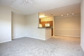 This single-floor residence offers a practical and comfortable layout designed for everyday living. The living area features soft, neutral-toned carpeting, a ceiling fan, and a large window that allows ample natural light and views of surrounding greenery, creating a bright and welcoming atmosphere. Track lighting adds a modern touch to the space.

The kitchen is efficiently arranged with warm oak cabinetry, dark granite-style countertops, and white appliances including a refrigerator, electric range, microwave, and dishwasher. Light tile flooring completes the functional design of this well-equipped cooking space.

The bedrooms are carpeted and finished in warm beige tones, each featuring ceiling fans and windows that bring in natural light. One bedroom includes a walk-in closet with built-in shelving, providing generous storage. An additional bedroom offers a dedicated closet and access to an adjoining bathroom.

The bathrooms are clean and simply appointed. One features a tiled soaking tub and shower combination with a small window for ventilation. The second bathroom includes a tiled walk-in shower, white cabinetry with dark countertops, and tile flooring. Throughout the residence, white six-panel doors and neutral wall tones create a cohesive and understated aesthetic.
