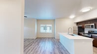 Located at 4142 E Morada in Stockton, CA, this well-designed single-floor unit offers a clean, modern aesthetic throughout. The open-concept living and kitchen area forms the heart of the home, featuring light-toned luxury vinyl plank flooring that runs seamlessly across the space. Large windows fitted with blinds allow natural light to fill the living room, which also benefits from a ceiling fan and direct access to an exterior door. The kitchen is outfitted with rich dark wood cabinetry, stainless steel appliances including a refrigerator and gas range, a dishwasher, and a white countertop island with a deep sink — an ideal setup for everyday cooking and entertaining. The bedroom is a comfortable, well-lit retreat with its own ceiling fan, a window with blinds, and easy access to a dedicated closet equipped with wire shelving for organized storage. The full bathroom is thoughtfully appointed with a white vanity, warm-toned countertop, gold-finish fixtures, wood-look LVP flooring, and a full soaking tub with a tiled surround. Neutral wall tones and consistent flooring throughout create a cohesive, move-in ready environment that is both functional and inviting.