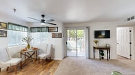Located at 5601 Natomas Blvd in Sacramento, CA, this 2-bedroom, 2-bathroom single-story unit offers a well-organized floor plan designed to maximize functionality. The living room features plush carpeting, a ceiling fan, and a sliding glass door that opens to a private patio, allowing natural light to fill the space and providing a seamless indoor-outdoor connection. Adjacent to the living area, the dining space flows naturally from both the living room and kitchen, creating an open, connected layout ideal for everyday living.

The kitchen is equipped with light wood cabinetry, granite-style countertops, black appliances including a range, microwave, dishwasher, and refrigerator, and a charming arched window above the sink that adds architectural interest. Wood-style flooring runs throughout the kitchen and dining area, complementing the warm, neutral tones of the space.

Both bedrooms offer carpeted floors and ceiling fans, with the primary bedroom featuring a closet and a window with natural light. The two bathrooms include single-sink vanities with matching cabinetry and countertops, with one bathroom featuring a tub-shower combination and wood-style flooring. An in-unit laundry area and hallway storage round out the practical amenities of this well-appointed Sacramento residence.