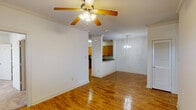 This contemporary 3-bedroom, 2-bathroom home in Gonzales, LA offers 1,150 square feet of thoughtfully designed living space. The interior is characterized by its bright, open layout and gleaming hardwood floors that run throughout the main living areas. Crown molding and ceiling fans with wooden blades add a touch of elegance and comfort to the rooms.

The kitchen is a highlight, featuring modern appliances including a black refrigerator and stove, complemented by light wood cabinetry and contrasting dark granite countertops. An over-the-range microwave and ample storage space make this kitchen both functional and stylish.

The bathrooms are well-appointed, with one featuring a shower/tub combination and the other a spacious vanity with granite countertop. Both offer clean lines and neutral color schemes for a fresh, modern feel.

Bedrooms are generously sized, with some featuring plush carpeting for added comfort. Large windows in each room allow for plenty of natural light, while providing privacy with horizontal blinds.

The home's layout includes a long hallway connecting the various rooms, enhancing the sense of space and flow. Built-in shelving in some areas offers additional storage or display options. Overall, this property presents a harmonious blend of modern amenities and comfortable living spaces.