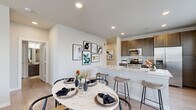 This single-floor residence offers 2 bedrooms, 3 bathrooms, and a well-organized open-concept layout designed for comfortable everyday living. The combined kitchen and living area serves as the heart of the home, featuring a sleek kitchen outfitted with dark wood cabinetry, granite countertops, a white subway tile backsplash, and a full suite of stainless steel appliances. A peninsula with bar seating flows seamlessly into the dining and living spaces, both of which benefit from recessed lighting and light wood-look flooring that extends throughout the home.

The living room receives generous natural light through large windows dressed with blinds and sheer curtains, creating a bright and welcoming atmosphere. Both bedrooms are well-proportioned, with the primary bedroom offering a spacious layout, large windows, and a ceiling fan. The second bedroom mirrors the same airy feel and comfortable scale. Each room connects to dedicated closet space, including a walk-in closet with wire shelving systems for organized storage.

The bathrooms are finished with clean, contemporary fixtures, including a soaking tub surrounded by white subway tile. A hallway with double closet doors adds additional storage convenience. Throughout, the home maintains a consistent neutral palette, modern finishes, and a cohesive, functional design.