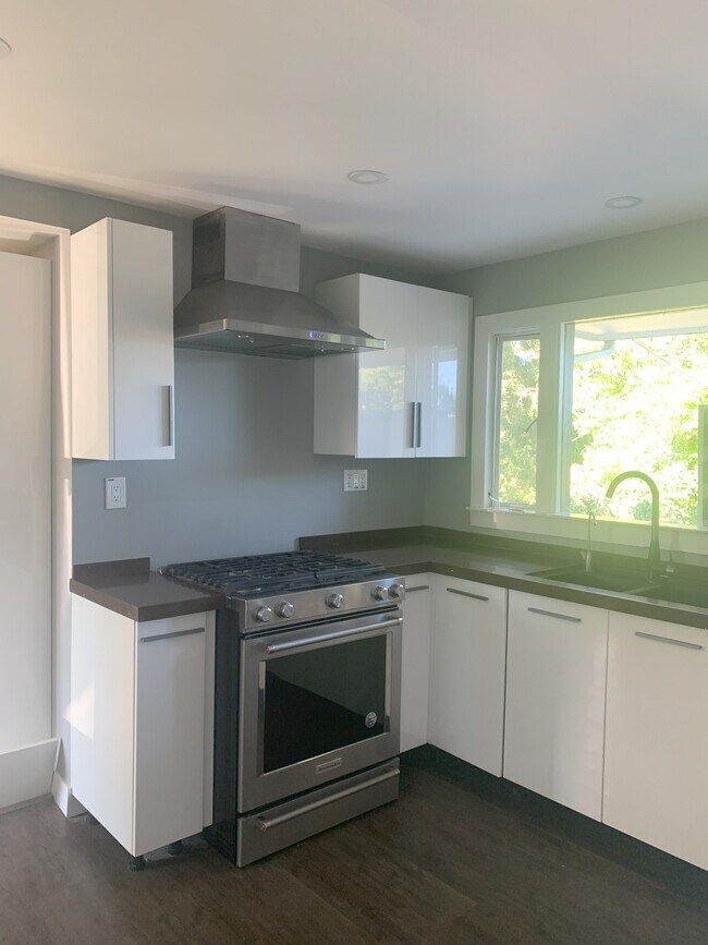 Granite kitchen countertops. Stainless steel gas range and hood - 815 108th Ave SE