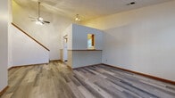 This two-story home in Pataskala, Ohio offers a practical and functional layout spread across two levels. The main floor provides the larger share of the living space, encompassing an open living room with wood-look plank flooring, a ceiling fan, and a textured ceiling. A distinctive pass-through window connects the living area to the kitchen, which features white cabinetry with warm wood-tone accents, light countertops, a double-basin sink, and a dishwasher. Natural light enters through a window above the sink. A separate entry area on the main floor also features large windows that allow ample natural light. The full bathroom is located on the upper level and includes a single-vanity with a mirrored cabinet, a tub-shower combination, and wood-look flooring.

The upper level hosts all three bedrooms, with the primary bedroom offering a ceiling fan and carpeted flooring. A secondary bedroom features notable vaulted ceilings with an upper window that draws in natural light, adding architectural interest. The third bedroom is carpeted and simply appointed. A dedicated closet with built-in shelving provides additional storage. Warm wood-tone doors and trim are consistent throughout the home, creating a cohesive interior aesthetic.