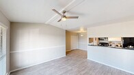 Located at 1111 Queens Rd in Pasadena, TX, this single-story home offers a practical and comfortable layout across two bedrooms, two bathrooms, a combined kitchen and living area, and a dedicated closet. The living room greets you with vaulted ceilings, light wood-style flooring, and a ceiling fan, creating an airy and open atmosphere. A pass-through counter seamlessly connects the living area to the galley-style kitchen, which features dark granite-style countertops, white cabinetry, black appliances including a refrigerator, electric range, dishwasher, and built-in microwave, all illuminated by track lighting overhead. Both bedrooms are carpeted and equipped with ceiling fans, offering a cozy feel, and each features windows with outdoor views that bring in natural light. The primary bedroom is a comfortable size with direct access to a bathroom featuring a dual-sink vanity with dark countertops and well-lit mirrors. A secondary bathroom serves the additional bedroom. Hardwood-style flooring flows through the main living areas, while carpet adds warmth to the bedrooms. The neutral color palette throughout the home gives it a clean, move-in-ready appearance suited for a variety of lifestyles.