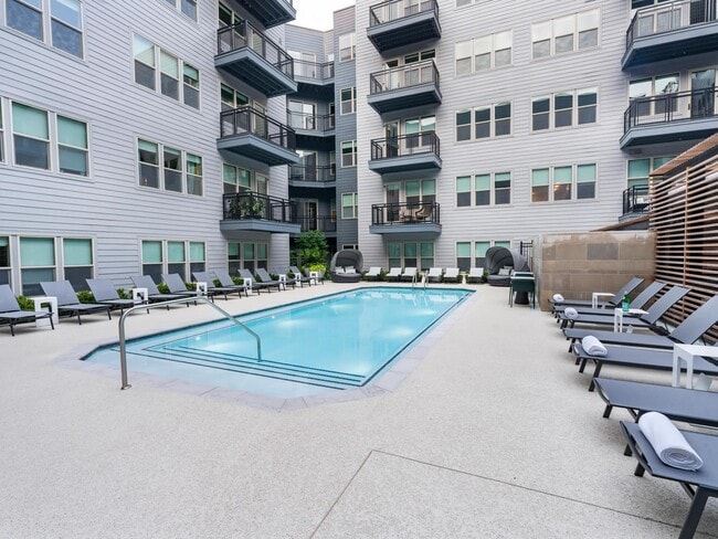 Relax by the sparkling courtyard pool—perfect for a refreshing dip or unwinding in a private lounge chair. - Modera Falls Church