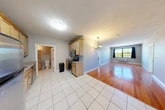 Located at 721 N Clinton St in Syracuse, NY, this single-floor residence offers three bedrooms, three full bathrooms, and four closets within a well-organized layout. The open kitchen flows directly into the living area and features light maple cabinetry, granite-look countertops, stainless steel appliances including an electric range, microwave, and refrigerator, and clean white tile flooring. A chandelier overhead adds a welcoming touch as the space transitions into the living room, where warm hardwood floors and large windows allow natural light to fill the room with outdoor views of surrounding greenery. Each bedroom is carpeted for comfort, with neutral-toned walls and good-sized windows. One bedroom features hardwood flooring and a large window with outdoor views, while the others offer plush carpet and easy closet access. The four closets include walk-in style options equipped with wire shelving systems, providing generous storage throughout. The three bathrooms are finished with white tile flooring, wood-toned vanities with granite-look countertops, lighted mirrors, and clean tub-and-shower combinations. The overall ambiance is clean, functional, and move-in ready, making this a practical and comfortable residence in Syracuse.