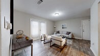 Located in Jackson, MS, this single-story residence offers a thoughtfully designed layout with 2 bedrooms, 4 bathrooms, a living room, dining room, kitchen, hallway, closet, and in-unit laundry. The living area features wood-look flooring and is bathed in natural light through large French doors with blinds, creating a bright and welcoming atmosphere. Adjacent to the living room, the dedicated dining area is illuminated by a pendant light fixture and also showcases the same durable wood-look flooring. The galley-style kitchen is equipped with white shaker cabinetry, light countertops, a stainless steel sink, and black appliances, with a direct sightline into the living area. The primary bedroom offers plush carpeting and a ceiling fan, with an en-suite bathroom featuring white cabinetry and elegant marble-look countertops. Additional bathrooms share the same refined finishes, including white vanities and marble-look surfaces. The carpeted walk-in closet includes built-in wire shelving for ample storage. A dedicated laundry room houses a full-size washer and dryer. Neutral tones throughout the space contribute to a clean, modern aesthetic.