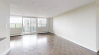 Located at 1340 Danforth Road in Toronto's Scarborough neighbourhood, this well-appointed one-bedroom, one-bathroom unit offers a comfortable and functional layout across a single floor. The living room is generously proportioned, featuring classic parquet hardwood flooring that runs throughout the main living areas and bedroom. Large floor-to-ceiling sliding glass doors open to a balcony, flooding the space with natural light and offering sweeping views of the surrounding cityscape and treetops. The kitchen is modern and well-equipped, showcasing white shaker-style cabinetry, a white subway tile backsplash, dark countertops, and a full suite of stainless steel appliances including a refrigerator, electric range, and built-in microwave. A peninsula counter provides additional workspace and defines the kitchen from the rest of the living area. The spacious primary bedroom includes mirrored sliding closet doors that enhance the sense of space, along with its own window and parquet flooring. The bathroom features a full bathtub and shower combo surrounded by classic white subway tile, with a small window for natural ventilation. Clean, neutral tones throughout lend the space a bright and airy ambiance.