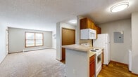 Located at 4605 W Chippewa Cir in Sioux Falls, SD, this single-floor, one-bedroom, one-bathroom unit offers a functional and well-organized layout. The open-concept main living area seamlessly combines the kitchen, dining, and living spaces into one cohesive zone. The galley-style kitchen is well-appointed with warm oak cabinetry on both sides, light countertops, a double-basin sink, and white appliances including a refrigerator, electric range, microwave, and dishwasher. Wood-look flooring runs throughout the kitchen, while plush carpet covers the living and dining areas. A ceiling fan provides added comfort to the main living space, which receives natural light through a front-facing window. The bedroom is a comfortable size, featuring carpet flooring, a ceiling fan, a window with natural light, and easy access to two closets. The bathroom is equipped with a full tub and shower combination with a curved curtain rod, wood-toned cabinetry, and wood-look flooring. A hallway connects the main living areas to the private quarters. A textured ceiling is consistent throughout the unit, and baseboard heating is present in multiple rooms.