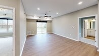 Located at 2635 N Forest Rd in Getzville, NY, this single-floor, three-bedroom, two-bathroom residence offers a well-designed layout with modern finishes throughout. The open-concept kitchen and living area serves as the heart of the home, featuring light hardwood-style flooring, recessed lighting, and a ceiling fan. The living room extends to a private balcony through sliding glass doors, allowing natural light to fill the space and providing outdoor views of the surrounding landscape.

The kitchen is appointed with white shaker cabinetry, granite countertops, stainless steel appliances including a gas range, microwave, and refrigerator, and a center island with a sink. An adjacent utility room conveniently houses a full-size washer and dryer.

The bedrooms feature neutral-toned carpet and generous natural light. The spacious primary bedroom includes a well-sized closet with wire shelving for organized storage. Both bathrooms are finished with light hardwood-style flooring, white cabinetry, and clean, neutral tones. One bathroom features a soaking tub and a second closet nearby for added convenience. The welcoming entryway opens to the main living areas with clean lines and a cohesive, neutral palette throughout.