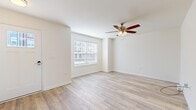 This two-story home offers a well-organized layout across two floors, providing three bedrooms, three bathrooms, and a range of functional living spaces. The ground floor hosts the main living and entertaining areas, including a living room finished with light wood-style flooring and a ceiling fan with integrated lighting. Natural light enters through windows fitted with blinds, maintaining a bright, neutral atmosphere throughout. The kitchen is a notable feature, equipped with dark espresso-toned cabinetry, granite-style countertops, stainless steel appliances including a refrigerator, range, microwave, and dishwasher, recessed lighting, and a pendant light above the sink area. Adjacent to the kitchen is a dedicated dining room with light hardwood-style flooring and a chandelier overhead. A dedicated laundry room with wire shelving and a full-size washer and dryer adds convenience on this level. The upper floor accommodates all three bedrooms, including a generously sized primary bedroom featuring vaulted ceilings, a ceiling fan, and plush carpeting. The secondary bedrooms are also carpeted and receive natural light. The bathrooms include vanities with granite-style countertops, dark wood cabinetry, and walk-in shower enclosures with brushed nickel fixtures.