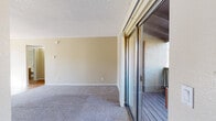Located at 7680 E Broadway Blvd in Tucson, Arizona, this single-floor, three-bedroom, two-bathroom residence offers a practical and well-organized layout. The galley-style kitchen is a functional highlight, featuring warm wood-toned cabinetry, light countertops, stainless steel appliances including a range and microwave, a double sink, and wood-look flooring that extends throughout the kitchen and wet areas.

The living area is carpeted and bathed in natural light, with sliding glass doors that open directly onto a private balcony—providing outdoor views of the surrounding Tucson architecture and greenery. The bedrooms are also carpeted and finished with neutral warm-toned walls and textured ceilings, creating a cohesive, comfortable atmosphere. The spacious primary bedroom features its own sliding glass door access to the balcony, while the secondary bedrooms offer windows with natural light and access to closet space.

Both bathrooms are equipped with shower-tub combinations and wood-look flooring, with one featuring a vanity with warm wood cabinetry. Additional spaces include a hallway, entrance area, and two closets, contributing to ample storage throughout. The unit's consistent neutral palette and functional design make it a well-rounded residential space in the heart of Tucson.