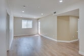 Located at 1311 Sepulveda Blvd in Torrance, California, this single-floor unit offers a thoughtfully designed layout with clean, contemporary finishes throughout. The open living area is anchored by warm wood-look flooring, neutral warm-toned walls, and recessed lighting that creates a bright and welcoming atmosphere. Natural light filters in through windows and a sliding glass door that opens to a private balcony, providing outdoor views of the surrounding neighborhood.

The kitchen is efficiently designed in a galley configuration, featuring white cabinetry, white quartz countertops, a tile mosaic backsplash, and a full suite of stainless steel appliances including a gas range, microwave, dishwasher, and refrigerator. A pass-through counter connects the kitchen to the living space, enhancing the open feel of the floor plan.

The unit includes two bathrooms. One bathroom offers a glass-enclosed walk-in shower with light tile flooring, while the second features a dual-sink vanity with white cabinetry, a large mirror, and a soaking tub, providing a spa-like experience. Both bathrooms are finished with porcelain tile flooring in a neutral palette. The entry area includes a closet and direct access to all main living spaces, making the overall layout practical and functional.