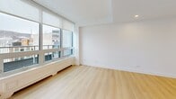 Located on Boulevard de Maisonneuve Ouest in the heart of Montréal, this well-appointed 2-bedroom, 1-bathroom unit offers a clean, contemporary design throughout. Light wood flooring flows seamlessly across the entire space, complementing the crisp white walls and creating a bright, cohesive aesthetic.

The open-concept living and dining area is bathed in natural light through large floor-to-ceiling windows, which frame expansive views of the Montréal cityscape and Mont-Royal. The kitchen is modern and functional, featuring white flat-panel cabinetry extending to the ceiling, white countertops, and a full suite of stainless steel appliances including a refrigerator, range, dishwasher, and over-the-range microwave.

Both bedrooms are generously proportioned, each equipped with sliding double-door closets and large windows that bring in ample natural light and city views. The primary bedroom offers a comfortable footprint well-suited for a full bedroom suite.

The bathroom is finished with neutral large-format floor and wall tiles, a white vanity, and a soaker tub with a frameless sliding glass shower enclosure, lending a clean, spa-like feel. Additional storage is provided by four closets distributed throughout the unit, along with a hallway that connects the living spaces efficiently.