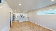 Located at 9658 Liam Loop Unit B in Missoula, Montana, this well-designed two-story home offers three bedrooms and three full bathrooms across two floors. The main level features an open-concept kitchen and living area bathed in natural light from large windows, with light wood-tone flooring flowing throughout. The kitchen is appointed with white shaker cabinetry, granite countertops, stainless steel appliances including an electric range, microwave, and dishwasher, and a matte black faucet at the double-basin sink. A modern glass-panel front door adds a contemporary touch to the entry, which connects directly to the staircase leading to the upper level. The upper floor hosts all three bedrooms, including a spacious primary suite with its own walk-in closet fitted with wire shelving and a dedicated ensuite bathroom featuring a walk-in shower, marble-style tile flooring, granite vanity, and matte black fixtures. The additional bathrooms mirror this refined aesthetic with tub-shower combos and matching finishes. Secondary bedrooms are bright and comfortable, each with light wood flooring and natural window light. The attached garage features an automatic opener and a clean concrete floor, providing convenient enclosed parking and additional storage space.