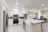 Located at 1029 W 223rd St in Torrance, CA, this single-story, 2-bedroom, 2-bathroom home offers a thoughtfully designed layout across a comfortable footprint. The modern kitchen is a standout feature, boasting white shaker cabinetry, stainless steel appliances including a range, dishwasher, and refrigerator, a mosaic tile backsplash, quartz countertops, and a peninsula that opens toward the dining area — ideal for both cooking and entertaining. The kitchen is finished with light tile flooring, complementing its bright and clean aesthetic. The living room features light wood-style flooring, recessed lighting, and a sliding glass door that brings in natural light and provides outdoor access. The adjoining dining area offers a cozy nook with additional built-in desk space. Both bedrooms are well-proportioned, with the spacious primary bedroom offering comfortable accommodations, while the second bedroom features a window with neighborhood views and wood-style flooring. The two bathrooms are finished in clean white tones with tile flooring, vanities with quartz countertops, and a tub-shower combination. A hallway and closet complete the efficiently organized floor plan, making this a functional and attractive single-floor home.