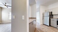 This single-floor residence offers a practical and comfortable layout designed for everyday living. The open living area is bright and welcoming, featuring wood-look plank flooring, neutral-toned walls, and multiple windows fitted with horizontal blinds that allow natural light to fill the space. A ceiling fan with a built-in light fixture adds both function and comfort to the room.

Adjacent to the living area, the dining space includes a pendant light fixture and a sliding glass door that opens to an outdoor area, providing seamless indoor-outdoor connectivity and additional natural light.

The kitchen is efficiently designed with gray cabinetry, laminate countertops, and stainless steel appliances including a refrigerator and dishwasher. An arched pass-through connects the kitchen to the rest of the living space, enhancing the open feel. A window above the sink brings in natural light.

The bedrooms are carpeted in a warm, neutral tone, offering a cozy and quiet retreat. Each room features soft gray walls and windows with blinds, creating a calm and restful atmosphere.

The bathroom includes a wide vanity with a drop-in sink, laminate countertop, and a large mirror, providing ample counter space. Clean white finishes and good lighting make the space feel bright and functional throughout.