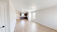 Located at 216 Flax Drive in Highland, Illinois, this two-story home offers a practical and well-appointed layout spread across two floors of nearly equal size. The main level features an open living room bathed in natural light from multiple windows, with light-toned hardwood-style flooring that flows seamlessly throughout. The kitchen is a standout, showcasing rich dark walnut cabinetry, white countertops, a double stainless steel sink with a matte black faucet, and stainless steel appliances including a gas range and refrigerator. A staircase connects the main level to the upper floor, where all three bedrooms are located. The spacious primary bedroom offers generous square footage with plush carpeting. The two additional bedrooms are well-sized, each featuring built-in closets with bi-fold doors and soft carpet flooring. Both bathrooms are clean and modern, with one featuring a full tub-and-shower combo equipped with matte black fixtures. Neutral paint tones, white panel doors with matte black hardware, and consistent finishes throughout the home create a cohesive and contemporary aesthetic. A hallway and dedicated closet space on the upper level add practical storage and circulation. The home also includes a dedicated staircase connecting both floors efficiently.