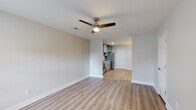 Located at 101 Cypress Plantation Rd in Moncks Corner, SC, this two-story home offers a thoughtfully designed layout across two floors. Light-toned luxury vinyl plank flooring flows consistently throughout, complemented by neutral gray walls, crisp white baseboards, and ceiling fans in the main living areas. The first floor hosts an open living room that connects seamlessly to a well-appointed kitchen. The kitchen stands out with gray shaker-style cabinetry extending to the ceiling, a classic white subway tile backsplash, light countertops, and a full suite of stainless steel appliances including a range, microwave, dishwasher, and refrigerator. A half bath is conveniently located on the main level. Natural light filters in through windows, brightening the living spaces. The staircase leads to the upper floor, where the generously sized primary bedroom offers ample room, a ceiling fan, and access to a large walk-in closet equipped with wire shelving and a high transom window. A full bathroom serves the upper level. The overall ambiance is clean, modern, and move-in ready, reflecting a fresh and functional design well-suited for comfortable everyday living.