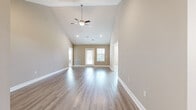 Located at 3491 SW 42nd St in Ocala, Florida, this single-story home offers a clean, modern aesthetic throughout its thoughtfully designed layout. The main living area immediately impresses with soaring vaulted ceilings, a ceiling fan with light fixture, and recessed lighting that brightens the open space. Durable wood-look flooring runs throughout the living areas, complementing the neutral warm-beige wall tones and crisp white baseboards that carry consistently through the home.

The kitchen is a functional standout, featuring rich dark-stained cabinetry paired with a classic white subway tile backsplash and granite countertops. A full suite of stainless steel appliances — including a refrigerator, range, microwave, and dishwasher — is included, along with a stainless undermount sink with modern faucet. The space is well-lit by a window and recessed overhead lighting.

The bedrooms offer plush carpeted flooring and ceiling fans, with generous natural light from multiple windows dressed with blinds. At least one bedroom includes access to a dedicated walk-in closet outfitted with multi-tier wire shelving and hanging rods, providing ample storage.

The bathroom features a tub-shower combination, a vanity with granite countertop and dark cabinetry, and brushed nickel fixtures throughout, rounding out this move-in-ready home.