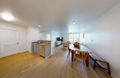 Located at 2323 Ellsworth Blvd in Ballston Spa, NY, this single-floor residence offers a thoughtfully arranged two-bedroom, two-bathroom layout with a clean, contemporary aesthetic throughout. Light-toned walls and light hardwood-style flooring run consistently through the main living areas, creating a cohesive and airy atmosphere.

The open-concept living, dining, and kitchen area forms the heart of the home. The living room features large windows that admit generous natural light and provide outdoor views, complementing the neutral, modern design. The adjacent dining area accommodates a full-sized table and connects seamlessly to the kitchen, which is equipped with stainless steel appliances—including a refrigerator, range, and microwave—granite countertops, and gray shaker-style cabinetry with ample storage, including a louvered pantry door.

The primary bedroom is a comfortable retreat with wall-mounted lighting and direct access to a private bathroom featuring a tiled walk-in shower. The second bathroom includes a full tub-shower combination with tile surround and chrome fixtures. Both bathrooms maintain consistent, clean finishes. The second bedroom offers additional flexibility for guests or a home office, completing this efficiently designed residence.