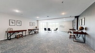 Located at 3425 Eischen Ct in Duluth, Minnesota, this well-appointed single-floor professional space offers a thoughtfully designed layout ideal for office or collaborative use. The interior is finished with neutral tones, patterned carpet tiles throughout, and recessed lighting that creates a clean, modern ambiance.

The main open area serves as a versatile lounge and workspace, featuring large windows that invite abundant natural light and views of the surrounding landscape. This central zone is furnished with individual desks along the walls, providing dedicated workstation areas, while a seating arrangement at the center accommodates group interaction or informal meetings.

A separate, enclosed conference room offers a more private setting, equipped with a substantial wooden table and ample seating for a full team. The room features clean white walls and recessed lighting, making it well-suited for focused meetings or presentations.

An additional workspace area, accented by a bold charcoal feature wall, houses individual desks and opens into the main lounge, offering flexible use as a private office or collaborative zone. Framed botanical artwork adds a refined decorative touch throughout.

The space also includes a fully ADA-accessible restroom, finished with classic white subway tile wainscoting, polished concrete-look flooring, stainless steel grab bars, and a wall-mounted vanity — combining practicality with a clean, contemporary aesthetic.