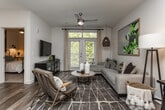 Located at 2400 Barrett Creek Blvd in Marietta, Georgia, this thoughtfully designed single-floor residence combines modern finishes with a warm, livable aesthetic throughout. Rich wood-look flooring flows continuously through the main living areas, anchoring each space with a cohesive, contemporary feel.

The kitchen is a standout feature, showcasing gray shaker-style cabinetry, granite countertops, a classic white tile backsplash, and a full suite of stainless steel appliances including a range, microwave, dishwasher, and refrigerator. A peninsula with pendant lighting and bar seating connects the kitchen to the dining and living areas, creating an open and functional layout ideal for both everyday use and entertaining.

The living area is bright and welcoming, with large windows and glass doors that invite natural light and offer views of lush greenery outside. The bedroom is a comfortable retreat, featuring a window with ample natural light, carpeted flooring, and a well-organized layout.

The bathroom is finished with granite-topped gray vanity cabinetry, a large mirror, and wood-look flooring, maintaining the same polished aesthetic found throughout the home. Every room reflects careful attention to detail, resulting in a cohesive and modern living environment.