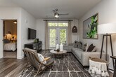 Located at 2400 Barrett Creek Blvd in Marietta, Georgia, this thoughtfully designed single-floor residence combines modern finishes with a warm, livable aesthetic throughout. Rich wood-look flooring flows continuously through the main living areas, anchoring each space with a cohesive, contemporary feel.

The kitchen is a standout feature, showcasing gray shaker-style cabinetry, granite countertops, a classic white tile backsplash, and a full suite of stainless steel appliances including a range, microwave, dishwasher, and refrigerator. A peninsula with pendant lighting and bar seating connects the kitchen to the dining and living areas, creating an open and functional layout ideal for both everyday use and entertaining.

The living area is bright and welcoming, with large windows and glass doors that invite natural light and offer views of lush greenery outside. The bedroom is a comfortable retreat, featuring a window with ample natural light, carpeted flooring, and a well-organized layout.

The bathroom is finished with granite-topped gray vanity cabinetry, a large mirror, and wood-look flooring, maintaining the same polished aesthetic found throughout the home. Every room reflects careful attention to detail, resulting in a cohesive and modern living environment.