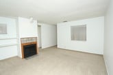 This single-story unit presents a straightforward, functional layout with a clean, neutral palette throughout. The floor plan, visible in the 3D model, reveals a linear arrangement of rooms connected by a central hallway, offering a practical flow between living spaces.

Multiple carpeted rooms serve as bedrooms, each finished with white walls, textured ceilings, and horizontal window blinds that allow for controlled natural light. Several rooms are equipped with ceiling fans fitted with light kits, adding both comfort and illumination. Windows in various rooms — including a sliding glass door in one space — provide natural light and outdoor views.

The galley-style kitchen features white cabinetry, light speckled countertops, wood-look flooring, a coil-burner electric range with overhead ventilation, and a stainless steel sink with a dishwasher. The streamlined layout maximizes efficiency within the space.

The bathrooms include wood-look vinyl flooring and feature a vanity with a drop-in sink, speckled countertop, chrome fixtures, and a large wall mirror with overhead lighting. The hallway connecting the bathroom to adjacent rooms maintains the same clean, light finishes found throughout the unit.