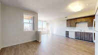 Located on 10th St E in Palmdale, CA, this well-appointed one-bedroom, one-bathroom unit offers a thoughtfully designed single-floor layout with a bright, modern aesthetic. The open-concept living and kitchen area serves as the heart of the unit, featuring warm wood-tone laminate flooring, crisp white walls, and abundant natural light streaming in through large windows with views of the surrounding neighborhood and distant mountains. Two balconies extend the living space outdoors, providing additional versatility.

The kitchen is efficiently designed with full-height dark wood-grain cabinetry offering generous storage, white countertops, a stainless undermount sink, a dishwasher, a range, and a full-size refrigerator. A hallway connects the main living area to the private bedroom, which is comfortably sized and features large windows with mountain and community views, light laminate flooring, and access to an adjacent balcony. Three closets throughout the unit provide ample storage.

The bathroom is well-proportioned, featuring dark wood-grain cabinetry beneath a large vanity mirror, a white countertop, and accessibility-friendly grab bars. Light laminate flooring continues throughout, creating a cohesive and easy-to-maintain interior. The overall ambiance is clean, contemporary, and move-in ready.