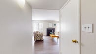 This single-story residence in Memphis, Tennessee offers a functional and well-organized layout across three bedrooms and two full bathrooms. The living room serves as the central gathering space, featuring wood-style flooring, a fireplace with a dark surround, and multiple windows with vertical blinds that allow natural light to fill the room. The open flow connects the living area to the dining room, which benefits from large sliding door access and additional windows, creating a bright and airy atmosphere suited for everyday dining.

The galley-style kitchen is efficiently designed with dark cabinetry contrasting against light countertops, a white electric range, a sink with ample counter space on either side, and a window that introduces additional natural light. Wood-style flooring continues throughout the kitchen.

Each bedroom features plush carpet flooring and vertical-blind windows. The primary bedroom includes a dedicated closet with built-in shelving, providing practical storage. The additional bedrooms are comparably sized and well-lit.

Both bathrooms are finished with wood-style flooring, dark vanity cabinetry, white countertops, and shower-tub combinations. A central hallway connects the bedrooms and bathrooms, contributing to the home's organized and cohesive flow throughout.