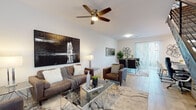 This two-floor residence presents a clean, contemporary design throughout its well-proportioned layout. The main living area is an open, light-filled space anchored by light wood-look flooring, a ceiling fan, and a seamless flow into the dining area, which benefits from natural light through sliding glass doors fitted with vertical blinds. The kitchen is outfitted with white shaker-style cabinetry, quartz countertops, stainless steel appliances, recessed lighting, and a peninsula that provides additional seating and prep space.

The primary bedroom is generously sized, featuring plush carpeting, sliding glass doors that invite natural light, and access to a spacious walk-in closet equipped with multiple shelving units and hanging rods along two walls. Additional bedrooms are carpeted and offer windows with natural light, providing flexible use as sleeping quarters or a sitting room. Two full bathrooms feature light wood-look tile flooring, white vanities with ample storage, and tub-shower combinations. The consistent use of neutral tones, clean lines, and modern finishes throughout creates a cohesive and functional living environment across both floors.