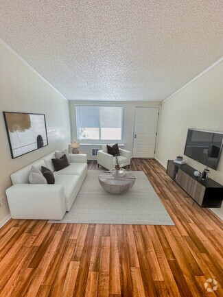 Relax in open-concept living rooms featuring vaulted ceilings that create an airy and expansive feel. - Concord Square Apartments
