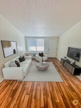 Relax in open-concept living rooms featuring vaulted ceilings that create an airy and expansive feel. - Summer Glen Apartments