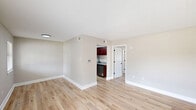 Located at 11585 N Harrell's Ferry Rd in Baton Rouge, Louisiana, this one-bedroom, one-bathroom unit offers a well-designed single-floor layout that makes smart use of its compact footprint. Light wood-style flooring runs throughout, complemented by neutral beige walls and white baseboards that create a clean, cohesive look across every room.

The living room is bright and open, featuring a large window that draws in natural light and offers a view of the surrounding neighborhood. A textured ceiling adds character to the space. The entry area includes a front door with a window alongside it and a smart thermostat panel mounted on the wall.

The galley-style kitchen is a standout feature, lined with rich, dark cherry wood cabinetry and granite countertops on both sides. Stainless steel appliances — including a refrigerator, range with electric coils, and dishwasher — provide full functionality, while a deep single-basin sink with a modern spring-neck faucet completes the setup.

The bedroom is a comfortable size, outfitted with a ceiling fan with light fixture, matching the living room's ceiling fan. The room is well-proportioned and benefits from natural light through a window.

The bathroom features a full tub-shower combination with white tile surround, a granite-topped vanity with warm wood cabinetry, and light wood-style flooring that ties back to the rest of the unit.