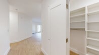 Located at 475 Main Street in the City of Orange, NJ, this modern one-bedroom, one-bathroom unit offers a thoughtfully designed layout with clean finishes throughout. Light wood-tone flooring flows seamlessly across the entire space, complementing the bright white walls and creating a warm, contemporary ambiance.

The open-concept kitchen and living area serves as the heart of the unit. The kitchen is outfitted with stainless steel appliances — including a refrigerator, range, microwave, and dishwasher — white cabinetry, and a peninsula countertop finished in elegant quartz with subtle veining, providing both additional prep space and casual seating. Recessed lighting illuminates the area throughout.

The living area is generously proportioned and benefits from a sliding glass door that invites natural light and provides access to an outdoor area. The bedroom features a window with exterior views and includes dedicated closet space. Three closets in total serve the unit, including a well-organized walk-in closet with built-in shelving and hanging rods for ample storage.

The bathroom is finished with large-format floor tiles, vertically stacked wall tiles in the tub surround, a soaking tub with a glass panel, and a modern floating vanity with warm wood-toned cabinetry. A dedicated laundry area and a connecting hallway complete the functional layout of this well-appointed unit.