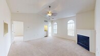 Located at 112 Shore Lake Dr in Greensboro, NC, this single-story home offers a well-organized layout with a bright, open feel throughout. The living room is a standout space, featuring vaulted ceilings, a ceiling fan, a fireplace, and elegant arched windows that fill the room with natural light and offer views of the surrounding landscape. A pass-through window connects the living area to the kitchen, enhancing the open flow between spaces. The galley-style kitchen is efficiently designed with white cabinetry, granite-look countertops, tile flooring, stainless steel appliances including an over-the-range microwave and double sink, and a dishwasher. Bedrooms are carpeted and well-lit, with arched windows providing natural light. At least one bedroom includes a walk-in closet with built-in shelving. The bathrooms are functional and clean, featuring white cabinetry, ample storage, tile flooring, and a tub-shower combination. A dedicated laundry room accommodates a full-size washer and dryer with overhead wire shelving for added storage. Throughout the home, neutral tones and plush carpeting in the living and sleeping areas contribute to a comfortable and cohesive atmosphere.