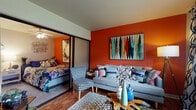 Located at 1361 Presidential Drive in Columbus, Ohio, this single-floor residence makes a striking first impression with its bold, warm orange accent walls that flow cohesively from the living area into the bedroom, creating a lively and energetic atmosphere throughout.

The living room is a welcoming space anchored by hardwood-style flooring, a large window dressed with patterned drapes that invite natural light, and a dedicated dining nook. A sliding door partition connects the living area to the bedroom, offering an open yet flexible layout.

The bedroom is carpeted for comfort and features a ceiling fan, an accent wall in the same warm orange tone, and direct access to the bathroom. The bathroom is finished with classic white subway tile, a white vanity with chrome fixtures, and a framed mirror — clean and functional in its design.

The kitchen is well-equipped with warm wood cabinetry, dark countertops, hardwood-style flooring, stainless steel appliances including a dishwasher and gas range, and track lighting overhead. The overall layout is efficient and practical, providing ample storage and counter space.

Together, these spaces form a cohesive, colorful home that balances bold design choices with everyday functionality in a convenient Columbus location.